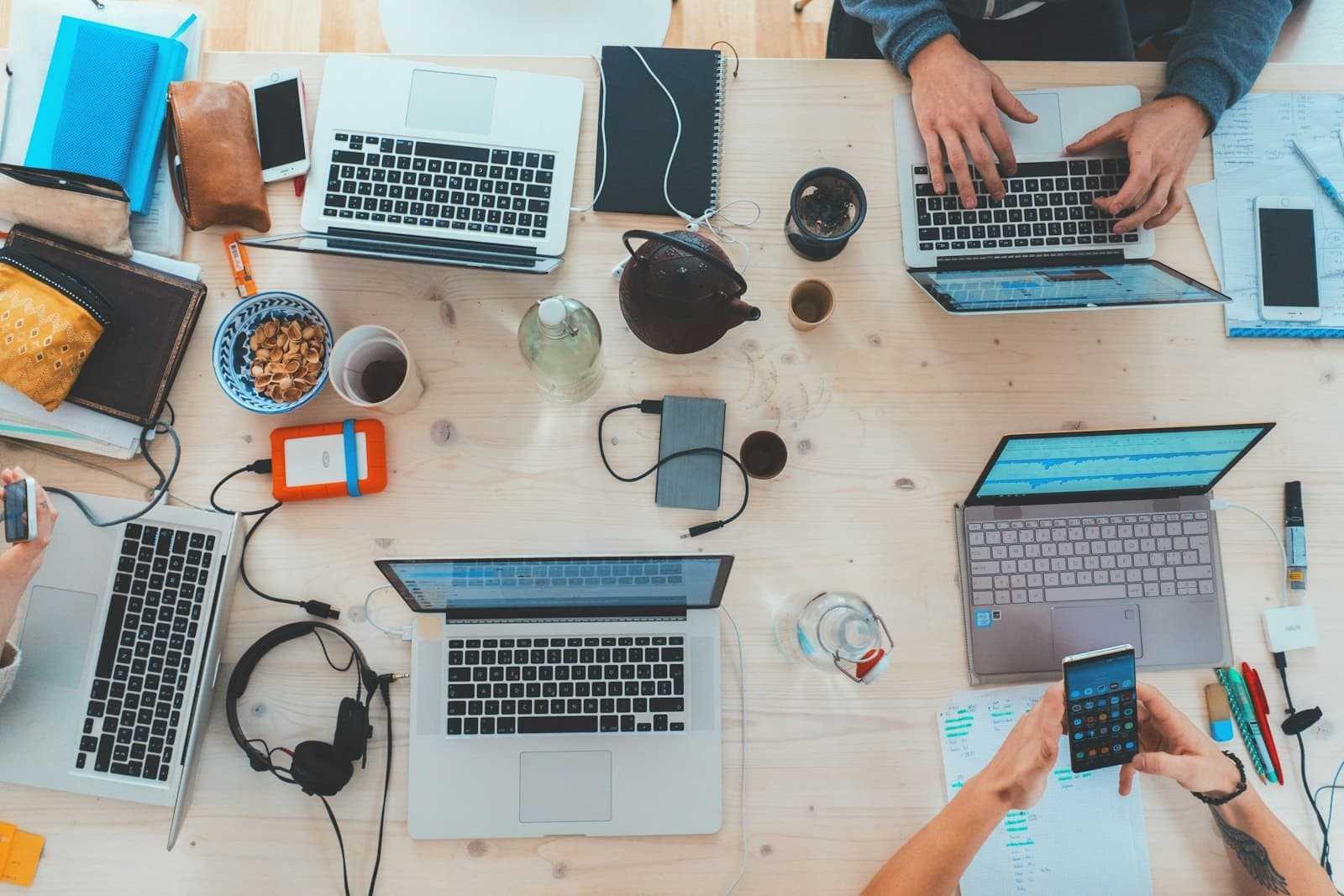 A team's laptops open around a table during onboarding